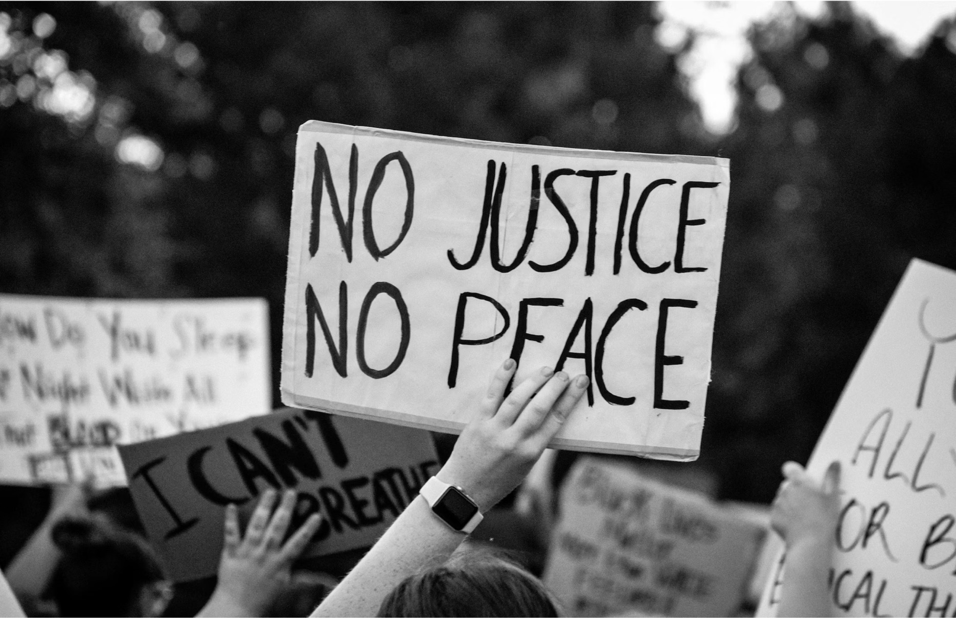 Editorial image of protests with sign that reads No Justice, No peace